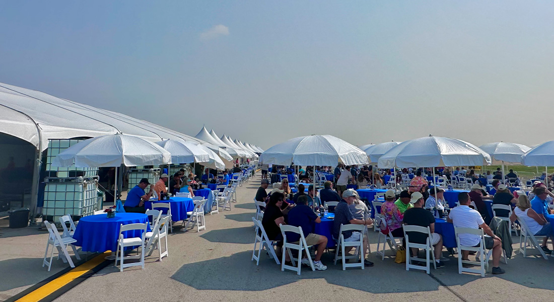 Columbus Air Show Rickenbacker Club - Private limited access area, catered food, drinks, shaded, private tables with umbrellas, Blue and white color scheme.