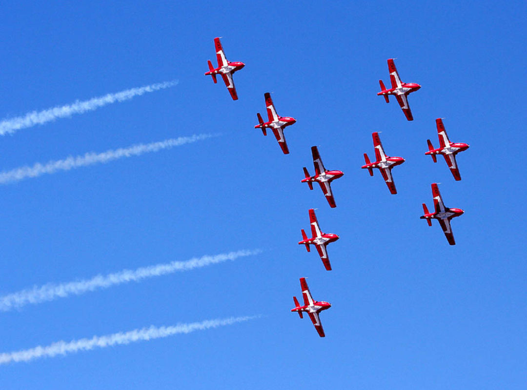 Canadian Forces Thunderbirds. Eight (8) CT-114 Tutors flying in formation on bright clear blue sky.