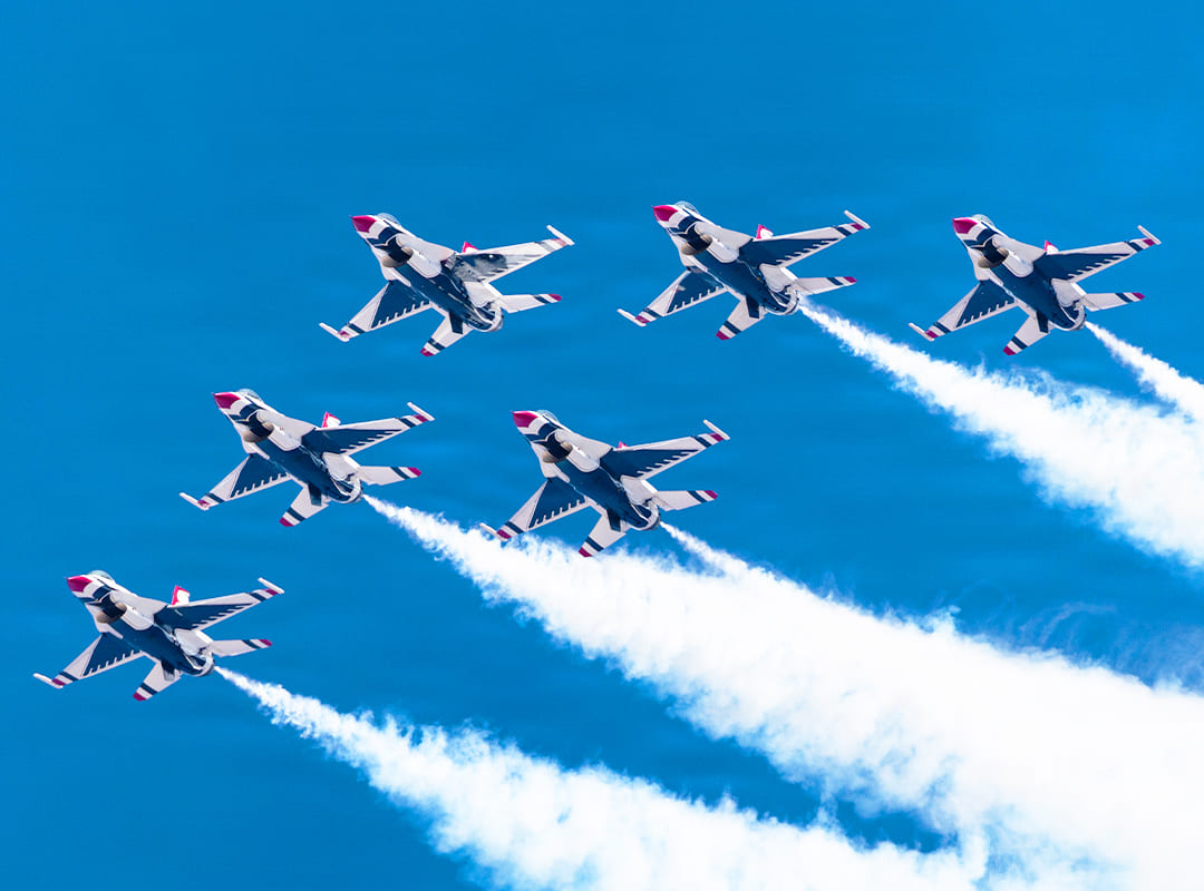 U.S. Air Force Thunderbirds flying against a clear blue sky.