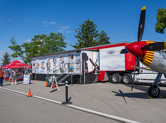 CAF Red Tail Squadron “Rise Above” mobile exhibit trailer with educational graphics and P-51 nose section displayed outside